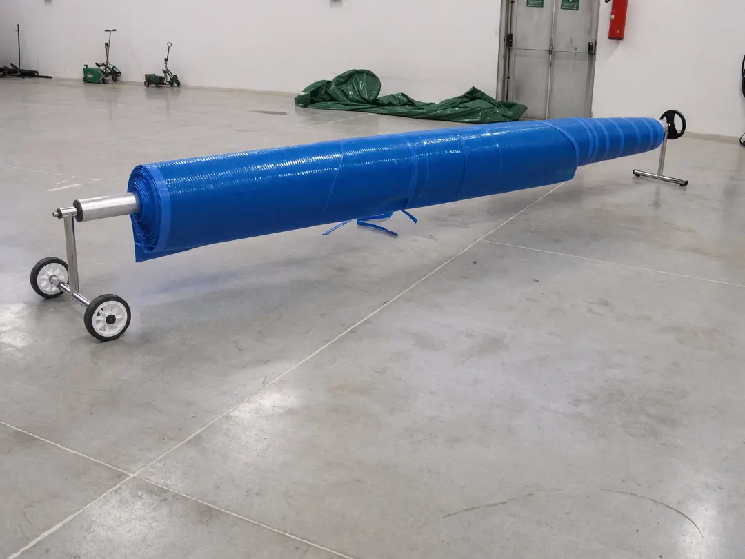 Summer cover wound onto its wheeled roller, in the Samarate workshop