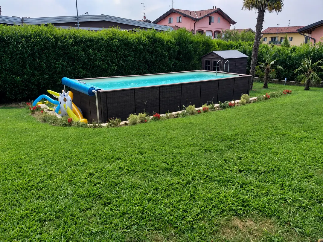 Above-ground pool with a summer cover on a roller resting on uprights
